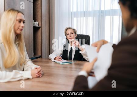 Trauriges Paar, das Dokumente mit einem Anwalt im Einvernehmen verfasst, beantragt oder Rechtsdokumente im Büro unterzeichnet. Verheirateter Mann und Frau, die Scheidung einreichen, Aktien Stockfoto