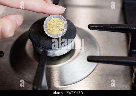 Die Gaskosten, die Eurokrise. Eine Euro-Münze auf dem Hintergrund eines Gasbrenners Stockfoto