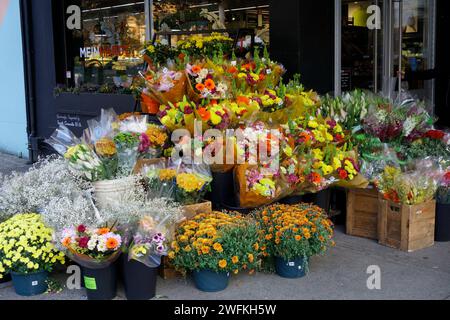 Schnittblumen und Topfblumen werden vor dem Lebensmittelgeschäft Meinhardt Fine Foods in South Granville, Vancouver, BC, Kanada ausgestellt Stockfoto