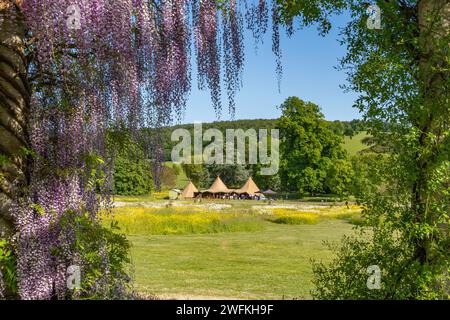 Ein Hochzeitsempfang in vollem Gange in den wunderschönen Gärten des West Dean College am Fuße der South Downs an einem herrlichen Sommernachmittag. Stockfoto