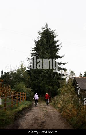 Biker-Paar, das Mountainbike im Wald auf dem Land fährt. Regnerischer Tag Stockfoto