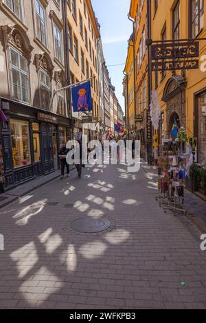 Ein wunderschöner Blick auf eine enge Touristenstraße in der Altstadt von Stockholm, Gamla Stan, an einem klaren sonnigen Tag. Schweden. Stockfoto