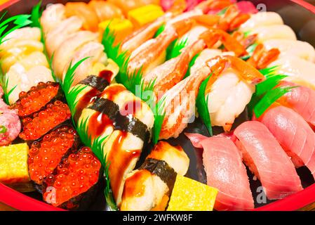 Handgepresstes Nigirizushi mit japanischen Meeresfrüchten, einschließlich Anago Congridae, Krabbenbeinen, Garnelen, mittelfettem Chūtoro-Thunfisch und Gunkanmaki gefüllt mit i Stockfoto