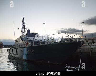 Lancha patrullera anclada en el puerto al atardecer Stockfoto