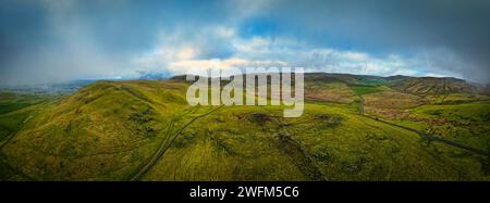 Malerische Landschaft mit üppigen grünen Feldern unter einem dramatischen Himmel mit Sonnenstrahlen, die durch Wolken ragen. Stockfoto