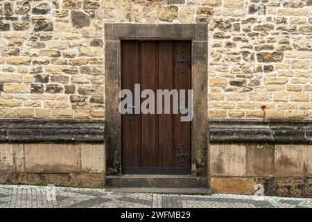 Die Tür eines mittelalterlichen gotischen Gebäudes aus Holz und Metall. Stockfoto