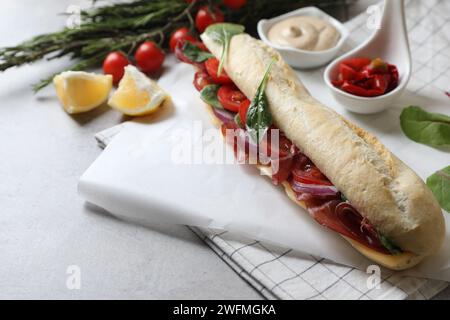 Köstliches Sandwich mit Bresaola auf hellgrauem Tisch Stockfoto