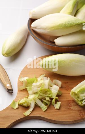 Frische rohe belgische Endivien (Zichorien) auf weißem Fliesentisch Stockfoto