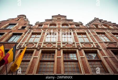 Backsteinfassade eines Gebäudes aus dem 17. Jahrhundert an der PT Rue au Beurre in Brüssel. Weitwinkelblick auf das traditionelle belgische Haus mit belgischer Flagge Stockfoto