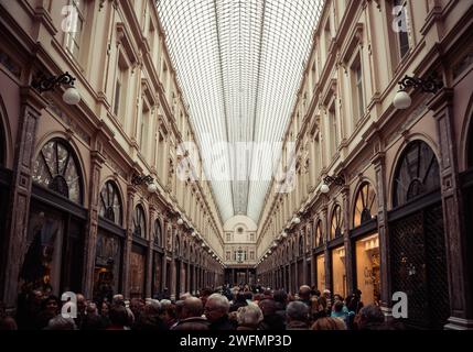 Royal Saint-Hubert Galeries in Brüssel. Schwindende Perspektive einer verglasten Einkaufspassage mit vielen Touristen, die entlang laufen Stockfoto