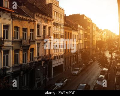 Sonnenaufgang auf der Rue Berckmans Straße im Viertel Saint-Gilles. Schwindender perspektivischer Blick auf die Straße am Morgen, Brüsseler Stadtbild in warmem Licht. Stockfoto