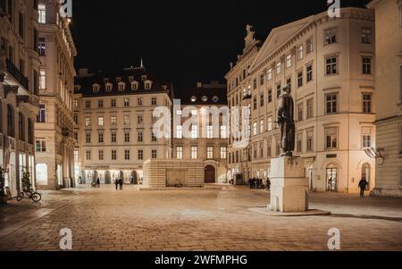 Judenplatz bei Nacht. Leerer Platz mit Holocaust-Mahnmal im Hintergrund und Gotthold Ephraim Lessing-Denkmal näher an der Kamera Stockfoto