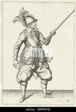 Soldat, der seine Spieße trägt, mit der linken Hand auf der rechten Seite, der Punkt nach oben geneigt, Jacques de Gheyn (II) (Werkstatt oder), nach Jacques de Gheyn (II), 1597 - 1607 drucken Einen Soldaten, nach, wer einen Spieß (Lanze) mit der linken Hand auf der rechten Seite trägt, der Punkt nach oben geneigt ist. Dies ist die zweite Aktion zum Absenken der Spieße, die unter einem Tresor durchlaufen werden können. Dieser Druck ist Teil der Serie von 32 nummerierten Abzügen von Spießen aus der Arms Handling. Niederlande Papiergravurmanöver  militärische Ausbildung. Kriegsführung; militärische Angelegenheiten (+ Söldnertruppen, z. B.: Lansquenets). Helved Weap Stockfoto