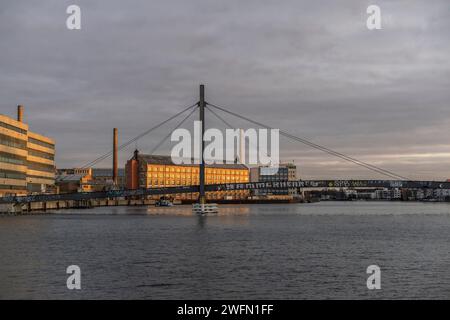 Das ehemalige unter Denkmalschutz stehende Kabelwerk Oberspree und die Kaisersteg-Brucke im Vordergrund bei Sonnenuntergang, Treptow - Köpenick, Berlin, Deutschland Stockfoto