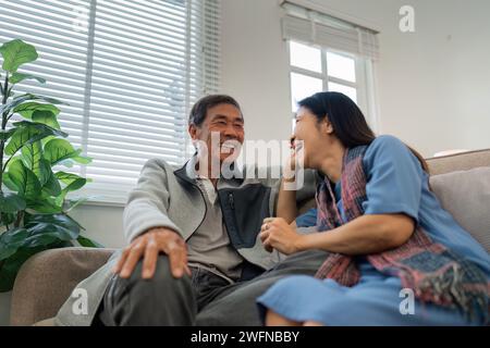 Ältere Paare sitzen und unterhalten sich entspannt und glücklich auf dem Sofa zu Hause an Wochentagen in komfortabler Atmosphäre Stockfoto