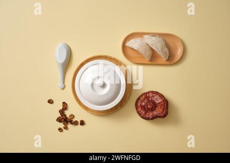 Eine weiße Schüssel, eine Holzschale mit essbaren Vogelnestern, Jujube-Scheiben (ziziphus jujujuba) und Lingzhi-Pilzen (Ganoderma Lucidum). Gesundheitswesen c Stockfoto