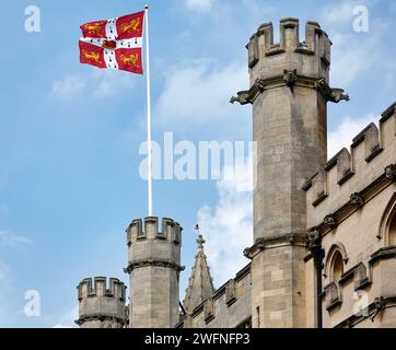 Die Flagge der Universität Cambridge winkt über die Mauern und Türme des Old Schools-Gebäudes. Universität Cambridge. Vereinigtes Königreich. Stockfoto