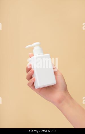 Ein weibliches Handmodell mit einem leeren Etikett in weiß. Werbeaktion für Reinigungs- oder Shampoo-Produkte Stockfoto