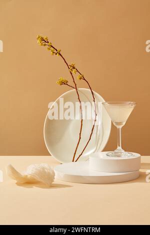 Weiße Podeste mit einem Glas Vogelnestsuppe auf der Oberseite, dekoriert mit einem Zweig gelber Blumen und essbaren Vogelnestern. Vogelnest bringt viel Nutzen Stockfoto