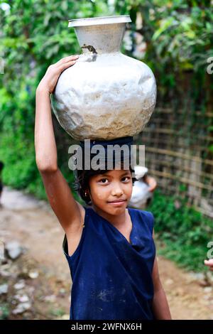 Junge arkanesische Mädchen, die Wasserkrüge in ihr Dorf in Mrauk-U im Staat Rakhine, Myanmar, tragen. Stockfoto