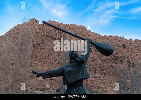 Sivrihisar, Eskisehir, Türkei - 24. Dezember 2023: Silhouettenansicht der Rückseite der Skulptur des Menschen Hold a baglama, ein türkisches Volksmusikinstrument Stockfoto