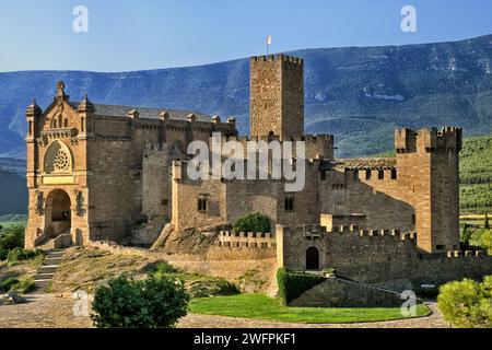 Castillo de Javier, 10. Jahrhundert, bei Sonnenuntergang, Basilika links, Schloss in Javier, Sierra de Leyre in der Ferne, Navarra, Spanien Stockfoto