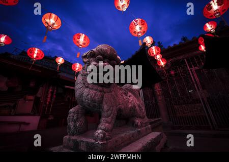 Der Tempel der chinesischen Göttin der Barmherzigkeit, Kuan Yin Teng, Löwenstatue, beleuchtet von Laternen während der chinesischen Neujahrsfeier, Georgetown, Penang, Malaiisch Stockfoto