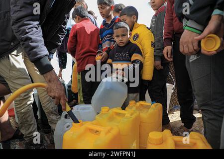 Rafah. Januar 31, 2024. Menschen stehen an, um Wasser in der Stadt Rafah im südlichen Gazastreifen zu holen, 31. Januar 2024. Quelle: Rizek Abdeljawad/Xinhua/Alamy Live News Stockfoto