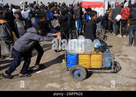 Rafah. Januar 31, 2024. Die Menschen kehren nach Hause zurück, nachdem sie Wasser in Rafah im südlichen Gazastreifen geholt haben, 31. Januar 2024. Quelle: Rizek Abdeljawad/Xinhua/Alamy Live News Stockfoto