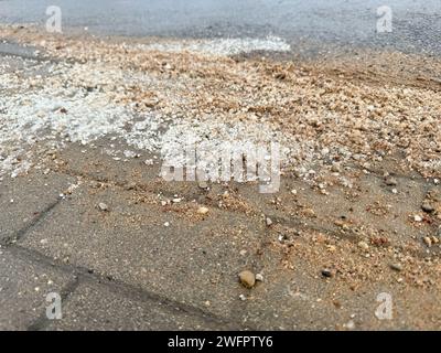 Salz auf dem Gehweg, um Schnee zu schmelzen, im Winter Straßen zu reinigen. Stockfoto