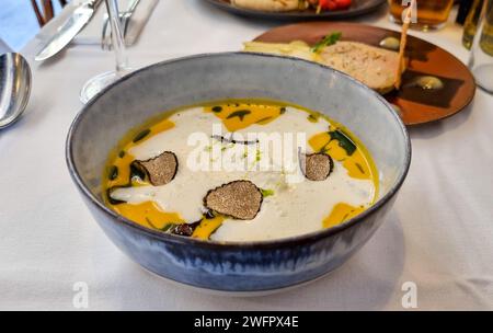 Eine Schüssel mit traditioneller französischer Kürbissuppe, garniert mit cremigen Strudeln, Croutons und schwarzem Trüffel Stockfoto