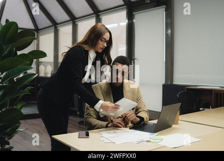 Mann, der am Tisch sitzt und am Laptop arbeitet. Stockfoto