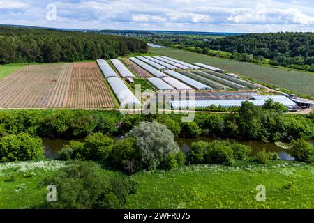 Luftaufnahme der Gewächshäuser der Bauern auf Feldern in der Nähe des Flusses Stockfoto