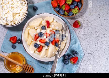 Hausgemachter Hüttenkäse gekochte Gnocchi mit Beeren, faule Teigtaschen Vareniki mit frischen Erdbeeren und Heidelbeeren Stockfoto