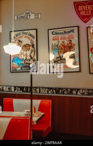 Inneneinrichtung in den 50er Jahren im amerikanischen Stil mit Plakaten an der Wand und roten Sofas Stockfoto