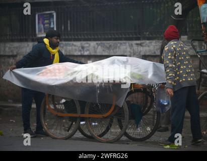 NOIDA, INDIEN - JANUAR 31: Pendler bei leichtem Regen im Winter, am 31. Januar 2024 in Noida, Indien. Es gab leichten Regen in Delhi NCR an einem kalten Tag, was die starke Kälte in Nordindien verstärkte. Heute wird es leichten Regen in Delhi-NCR geben. Laut IMD betrug die Mindesttemperatur 11 Grad Celsius. (Foto: Sunil Ghosh/Hindustan Times/SIPA USA) Credit: SIPA USA/Alamy Live News Stockfoto