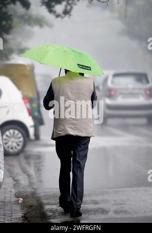 NOIDA, INDIEN - JANUAR 31: Pendler bei leichtem Regen im Winter, am 31. Januar 2024 in Noida, Indien. Es gab leichten Regen in Delhi NCR an einem kalten Tag, was die starke Kälte in Nordindien verstärkte. Heute wird es leichten Regen in Delhi-NCR geben. Laut IMD betrug die Mindesttemperatur 11 Grad Celsius. (Foto: Sunil Ghosh/Hindustan Times/SIPA USA) Credit: SIPA USA/Alamy Live News Stockfoto