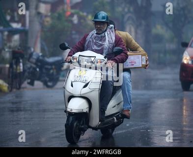 NOIDA, INDIEN - JANUAR 31: Pendler bei leichtem Regen im Winter, am 31. Januar 2024 in Noida, Indien. Es gab leichten Regen in Delhi NCR an einem kalten Tag, was die starke Kälte in Nordindien verstärkte. Heute wird es leichten Regen in Delhi-NCR geben. Laut IMD betrug die Mindesttemperatur 11 Grad Celsius. (Foto: Sunil Ghosh/Hindustan Times/SIPA USA) Credit: SIPA USA/Alamy Live News Stockfoto