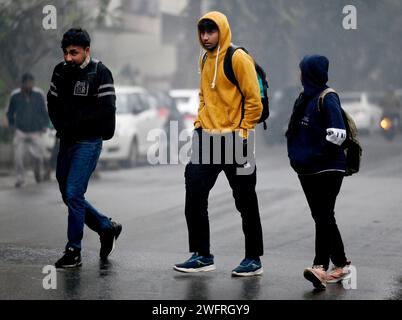 NOIDA, INDIEN - JANUAR 31: Pendler bei leichtem Regen im Winter, am 31. Januar 2024 in Noida, Indien. Es gab leichten Regen in Delhi NCR an einem kalten Tag, was die starke Kälte in Nordindien verstärkte. Heute wird es leichten Regen in Delhi-NCR geben. Laut IMD betrug die Mindesttemperatur 11 Grad Celsius. (Foto: Sunil Ghosh/Hindustan Times/SIPA USA) Credit: SIPA USA/Alamy Live News Stockfoto