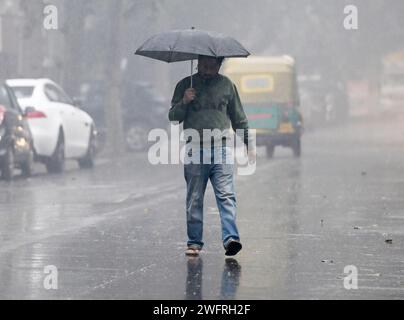 NOIDA, INDIEN - JANUAR 31: Pendler bei leichtem Regen im Winter, am 31. Januar 2024 in Noida, Indien. Es gab leichten Regen in Delhi NCR an einem kalten Tag, was die starke Kälte in Nordindien verstärkte. Heute wird es leichten Regen in Delhi-NCR geben. Laut IMD betrug die Mindesttemperatur 11 Grad Celsius. (Foto: Sunil Ghosh/Hindustan Times/SIPA USA) Credit: SIPA USA/Alamy Live News Stockfoto