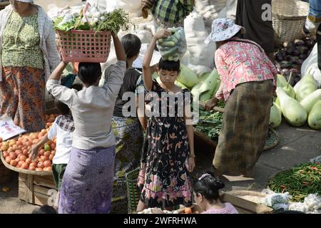 22/2014 - Yangon, Myanmar: Menschen kaufen und verkaufen frisches Gemüse auf einem belebten Freiluftmarkt in Yangon, Myanmar, mit Schwerpunkt auf traditionellem Gemüse Stockfoto