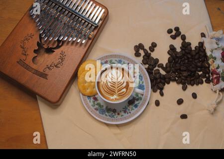 Ein Blick von oben auf eine Tasse heißen Kaffee mit Kaffeebohnen auf dem Tisch Stockfoto