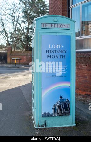 Eton, Windsor, Großbritannien. Februar 2024. Eine Gemeinschaftsbibliothek, ehemalige Telefonbox vor der berühmten öffentlichen Schule des Eton College mit einem Banner zum LGBT+ History Month, der heute beginnt. Der Direktor des Eton College, Simon Henderson, der den Spitznamen „Trendy Hendy“ trägt, hat zuvor gesagt, dass er unverschämt „geweckt“ sei. Letztes Jahr schuf er eine neue Rolle als „Leiter der Inklusion Education“, um die Bemühungen um Vielfalt an der Schule zu überwachen. Quelle: Maureen McLean/Alamy Live News Stockfoto