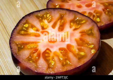 Ein Querschnitt einer Purple Boy Tomato, die die Abschnitte ihres üppigen Fleisches zeigt Stockfoto