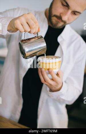 Ein Barista in der Nähe einer Espressomaschine bereitet leckeren Kaffee zu. Ein junger Mann bereitet Kaffee in einem Café zu. Stockfoto