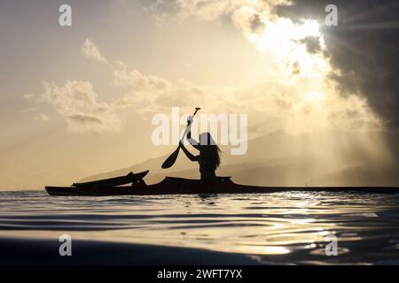 Französisch-Polynesien, Tahiti: Surfplatz in Teahupo'o: Silhouette einer Frau in einem Boot, eine traditionelle polynesische Piroge. Teahupos ist für den Gastgeber geplant Stockfoto