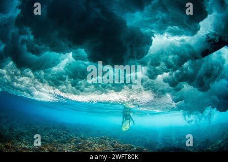 Französisch-Polynesien, Tahiti: Surfplatz in Teahupo'o: Frau, Surfer unter Wasser, unter der Welle. In Teahupos wird der Surfwettbewerb ausgetragen Stockfoto