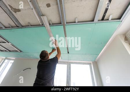 Drywall Installers. Men holding a gypsum board figured cut Stockfoto