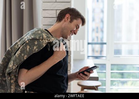 Junger Soldat, der zu Hause kommuniziert. Stockfoto