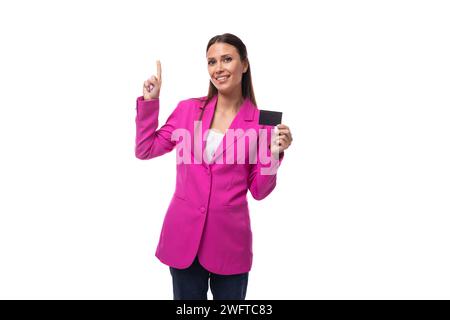 Die junge Boss-Frau in einer rosa Jacke zeigt eine Kreditkarte mit einem Mockup Stockfoto